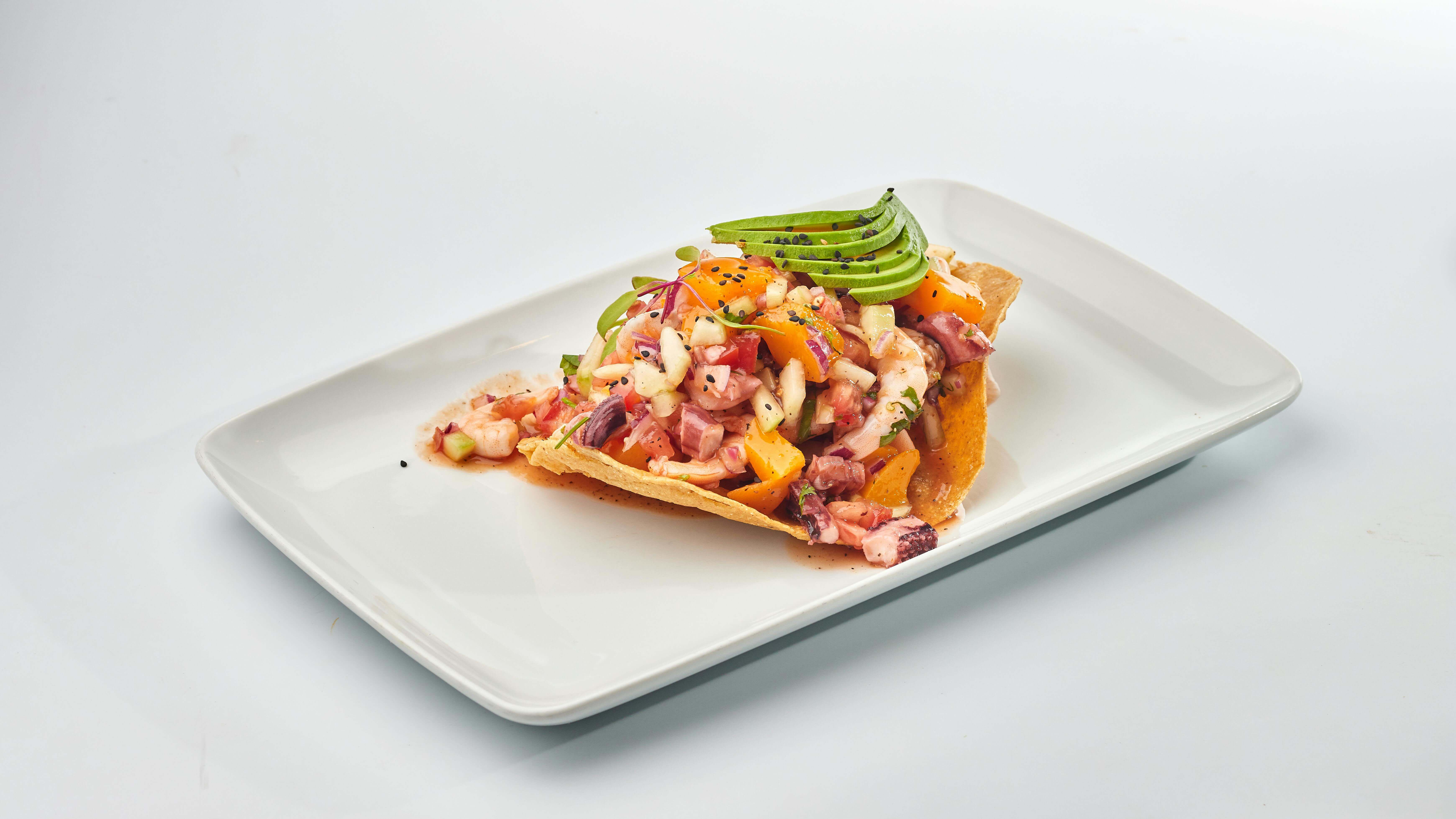 Shrimp ceviche prepared with tomato citrus and avocado showing a colorful Latin American style recipe.