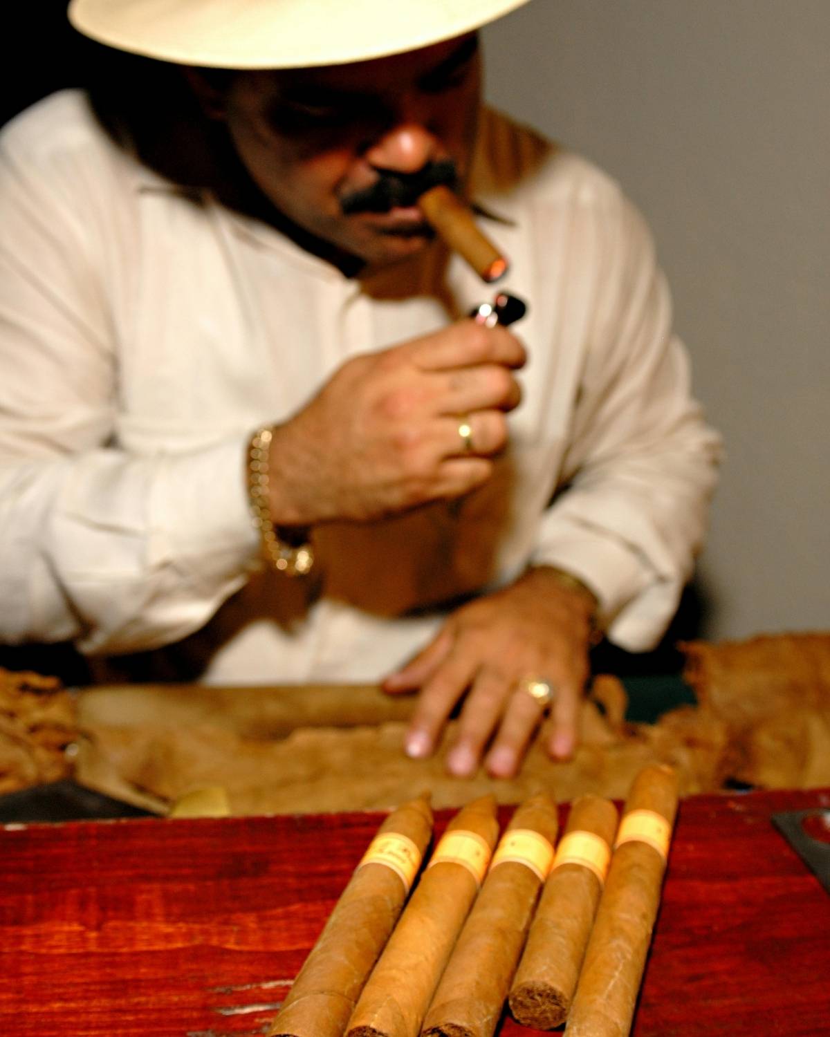 man with beard and panama hat smoking cigars